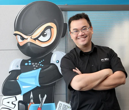 Melvin Foo standing beside the PC Ninja mascot